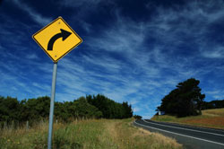 photo of road sign indicating curve ahead