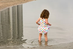photo of girl wading into water